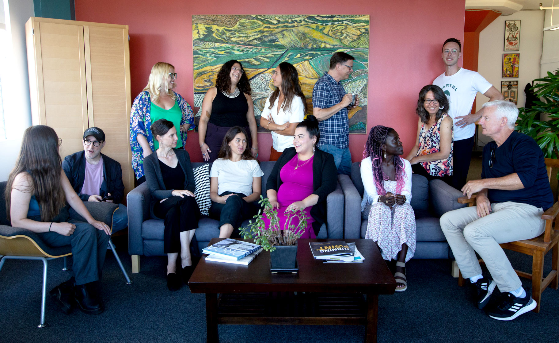 Group of 13 Pyramid staff, standing and sitting, having a variety of conversations