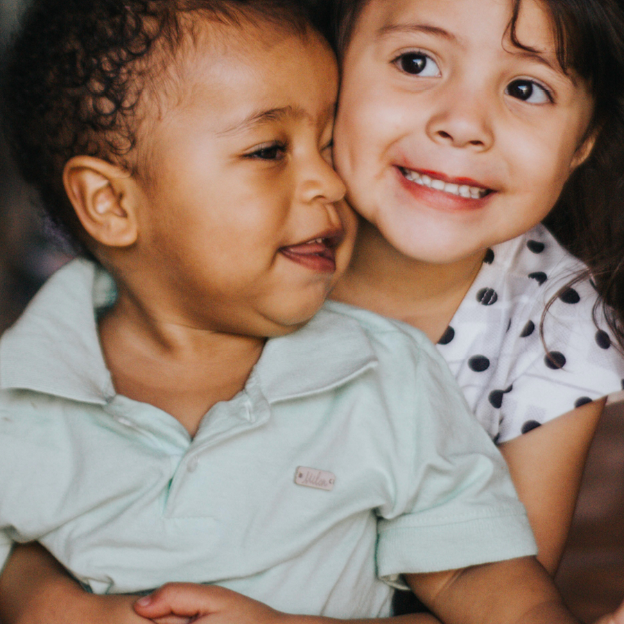 Two young kids hugging each other